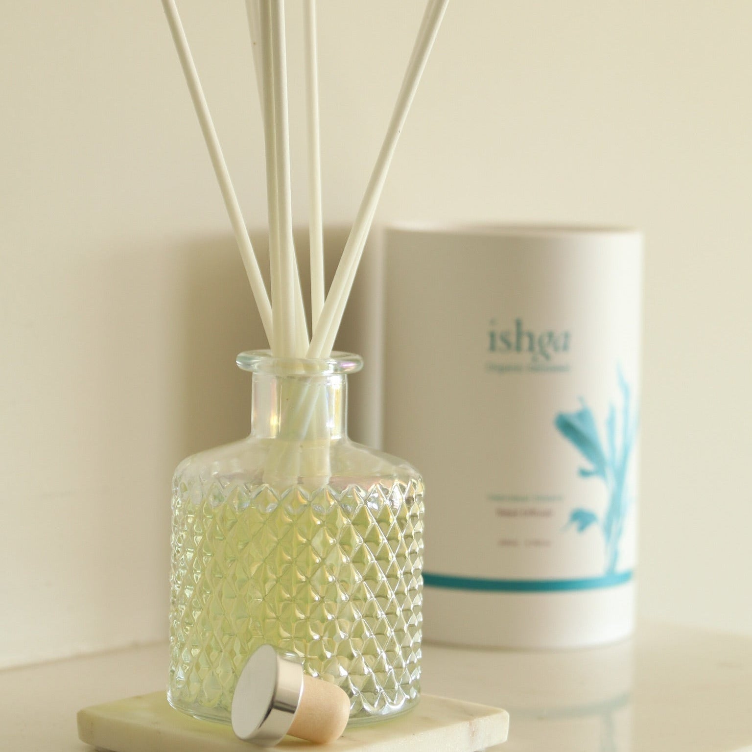 Diffuser with reeds and a container labeled 'ishga' on a light surface.